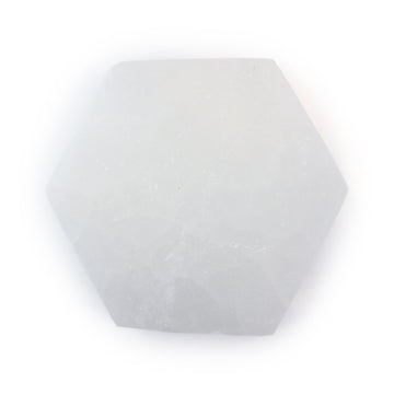 Top view of a polished selenite hexagon coaster showing its translucent white glow and natural texture on a white background.